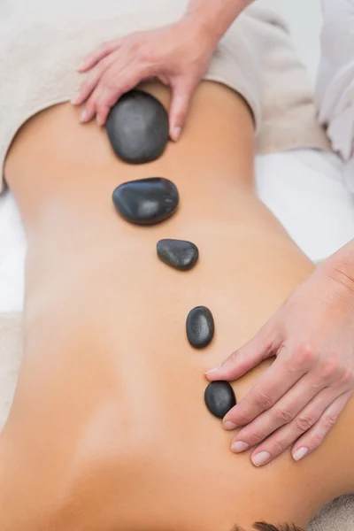 Mulher bonita recebendo massagem de pedra no centro de spa — Fotografia de Stock