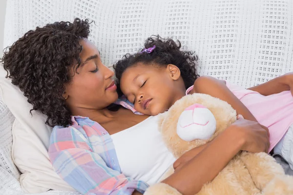 Linda hija durmiendo con la madre en el sofá — Foto de Stock