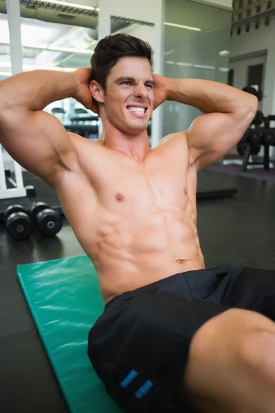 Determined muscular man doing abdominal crunches — Stock Photo, Image