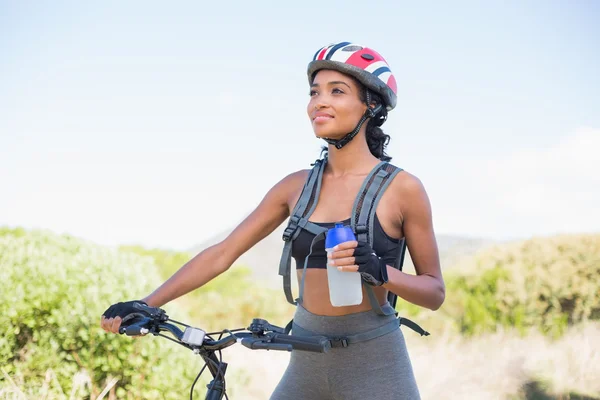 Fitte Frau geht mit Wasserflasche auf Radtour — Stockfoto