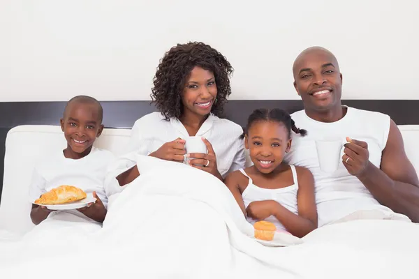 Happy family having breakfast in bed — Stock Photo, Image