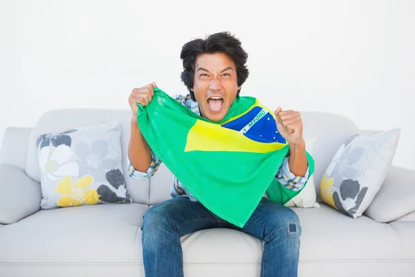 Football fan cheering and holding brazil flag — Stock Photo, Image