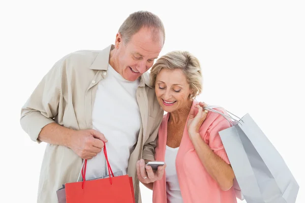 Smiling older couple holding shopping bags — Stock Photo, Image