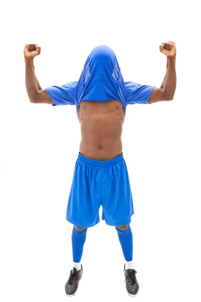 Joueur de football excité en bleu acclamant avec maillot au-dessus de la tête — Photo