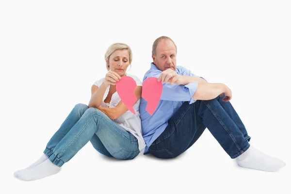 Sad mature couple holding a broken heart — Stock Photo, Image