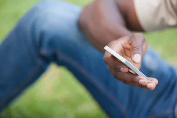 Hombre relajándose en su jardín mensajes de texto en el teléfono — Foto de Stock