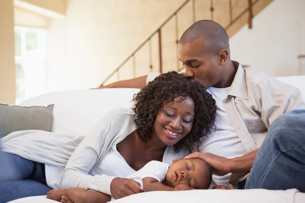 Baby boy sleeping peacefully on couch with happy parents — Stock Photo, Image