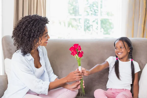 Vackra mamma med sin dotter erbjuder rosor — Stockfoto