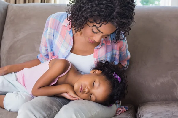 Linda hija durmiendo a través de madres regazo en el sofá —  Fotos de Stock