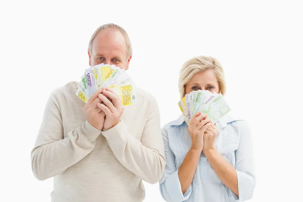 Feliz pareja madura sonriendo a la cámara mostrando dinero — Foto de Stock