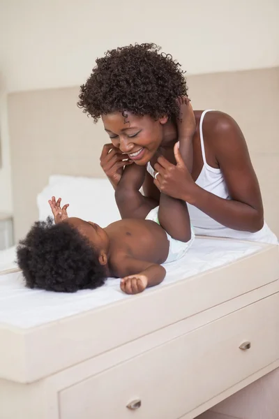 Mère avec bébé fille sur table à langer — Photo