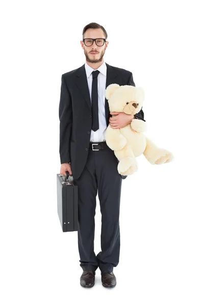 Geeky businessman holding briefcase and teddy — Stock Photo, Image