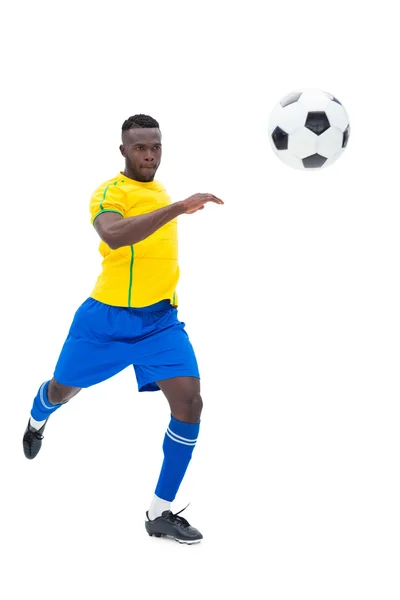 Jogador de futebol em amarelo chutando bola — Fotografia de Stock