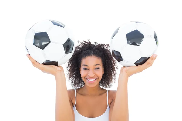 Chica bonita sosteniendo balones de fútbol y sonriendo a la cámara —  Fotos de Stock