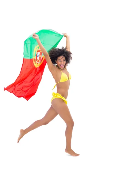 Девушка в желтом бикини, держащая в руках флаг — стоковое фото