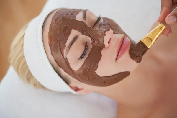 Loira bonita recebendo um tratamento facial de chocolate — Fotografia de Stock