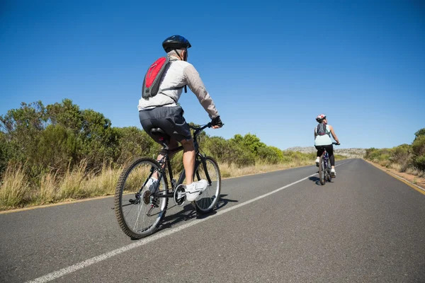 Aktiva par går för en cykel rida på landsbygden — Stockfoto