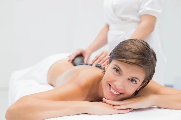 Schöne Frau erhält Steinmassage im Wellness-Center — Stockfoto