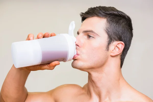 Närbild av en sportig ung man dricka protein — Stockfoto