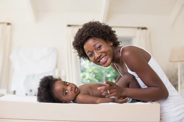 Mãe feliz com bebê menina na mesa de mudança — Fotografia de Stock