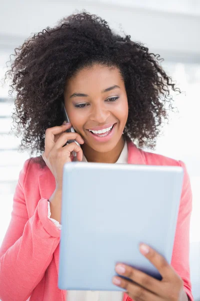 Casual businesswoman talking on phone holding tablet pc — Stock Photo, Image