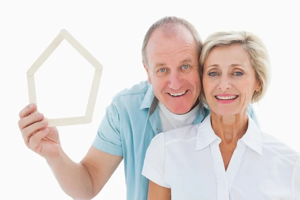 Happy older couple holding house shape — Stock Photo, Image