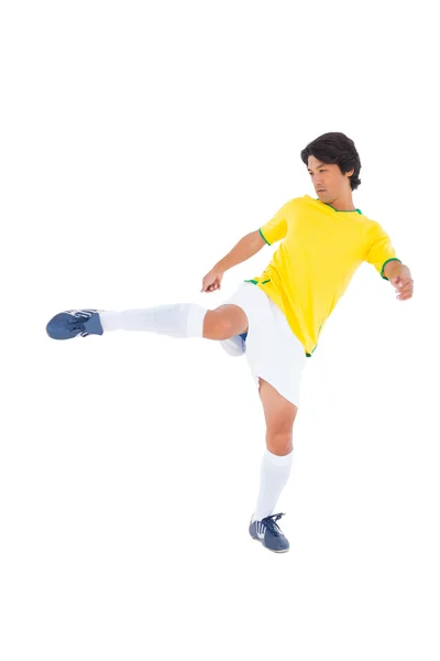 Football player in yellow kicking — Stock Photo, Image