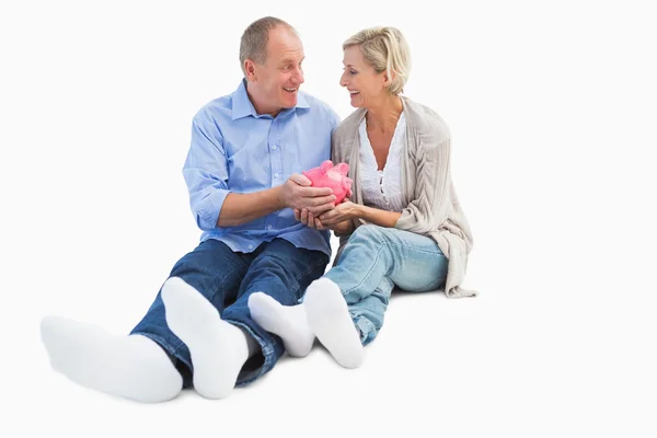 Feliz maduro casal segurando porquinho banco — Fotografia de Stock