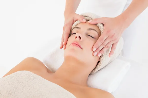 Jovem atraente recebendo massagem facial no centro de spa — Fotografia de Stock