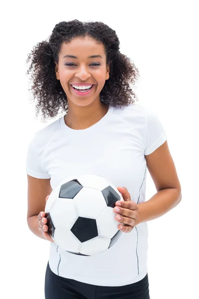 Красивый футбольный фанат в белом, держащий мяч, улыбающийся в камеру — стоковое фото