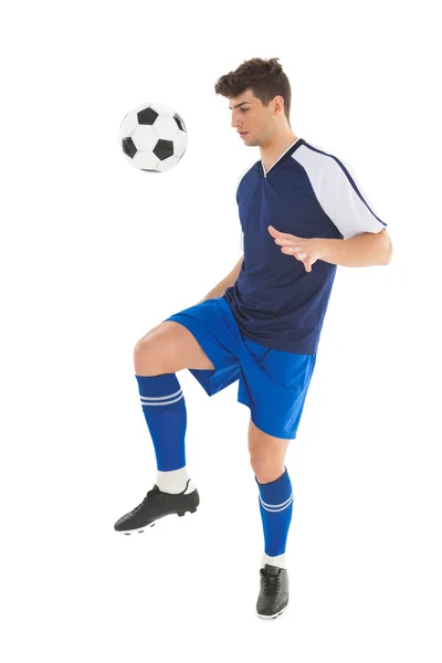 Jogador de futebol em camisa azul chutando bola — Fotografia de Stock