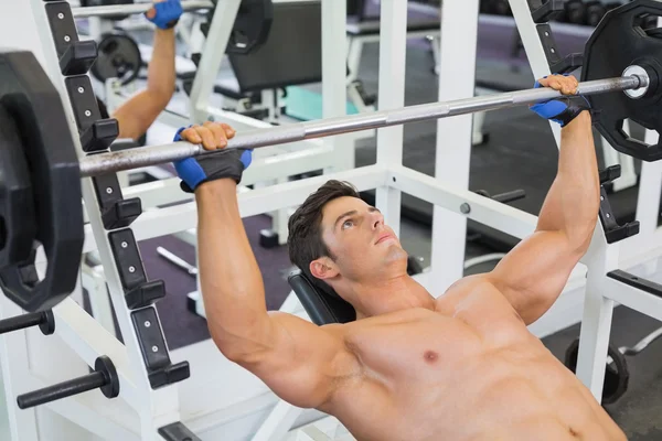 Homme musclé sans chemise levant haltère dans la salle de gym — Photo