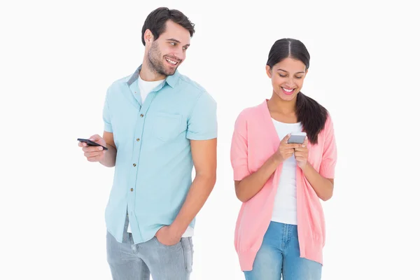 Happy couple sending text messages — Stock Photo, Image