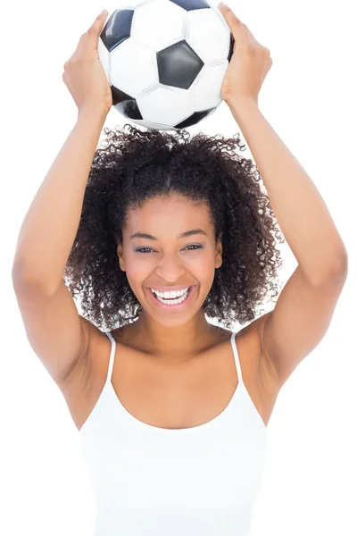 Menina bonita com penteado afro sorrindo para câmera segurando footba — Fotografia de Stock
