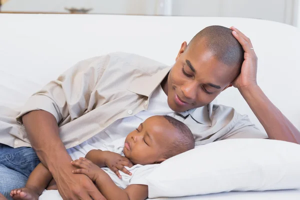 Happy young father with baby son on couch — Stock Photo, Image