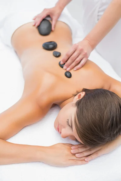 Schöne Frau erhält Steinmassage im Wellness-Center — Stockfoto