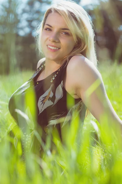 Jolie blonde en robe de soleil assise sur l'herbe — Photo