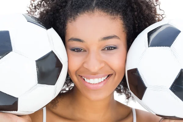 Pretty girl with afro hairstyle smiling at camera holding footba — Stock Photo, Image