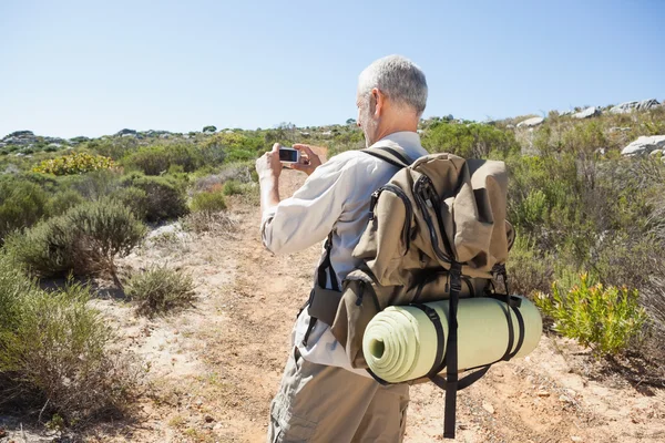 Bellissimo escursionista che scatta una foto in campagna — Foto Stock