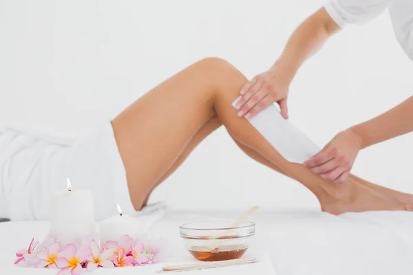 Therapist waxing woman's leg at spa center — Stock Photo, Image