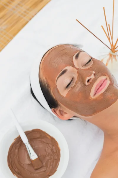 Smiling brunette getting a mud treatment facial — Stock Photo, Image