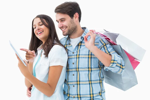 Attractive young couple with shopping bags and tablet pc — Stock Photo, Image