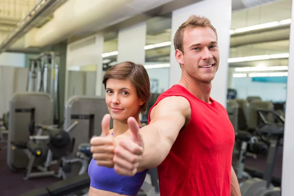 Fit attraktives Paar lächelt in die Kamera und zeigt Daumen hoch — Stockfoto