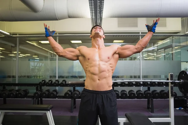 Bodybuilder with arms raised in gym — Stock Photo, Image