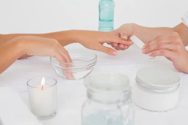 Beautician limando las uñas de una clienta en el salón de belleza del spa — Foto de Stock