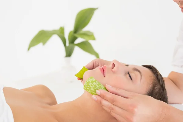 Attractive young woman receiving aloe vera massage at spa center — Stock Photo, Image