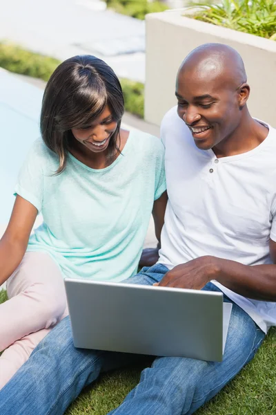 Casal feliz usando laptop juntos fora — Fotografia de Stock