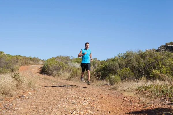 Atletische man joggen op land trail — Stockfoto