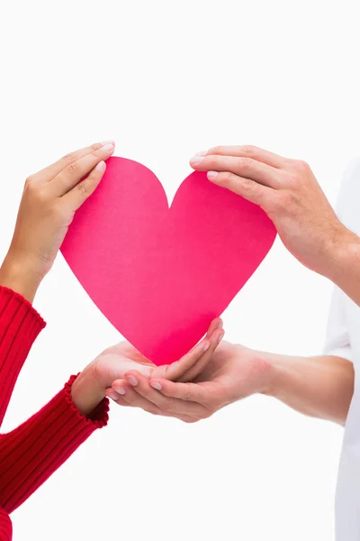 Couples hands holding pink heart — Stock Photo, Image