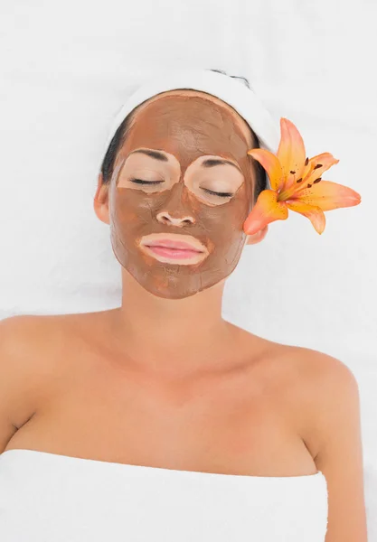 Smiling brunette getting a mud treatment facial — Stock Photo, Image